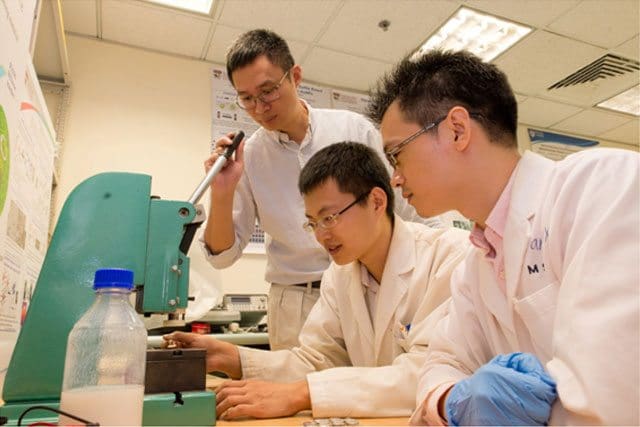 De gauche à droite, le professeur Chen Xiaodong supervise le travail de deux membres de son équipe, Tang Yuxin et Deng Jiyang