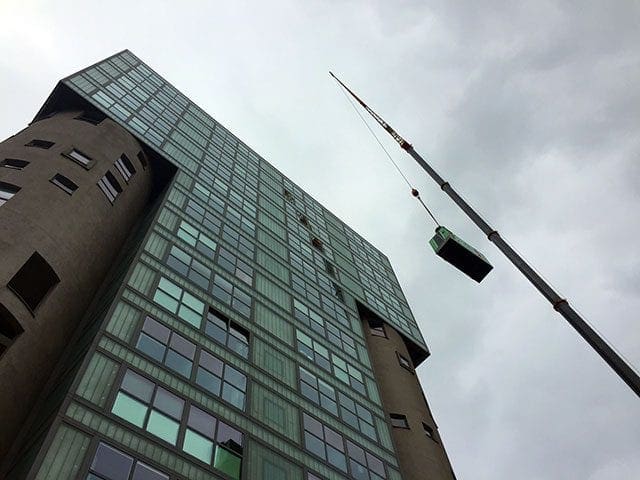 Subiendo mediante una grua el grupo electrógeno INMESOL, a lo alto del edificio
